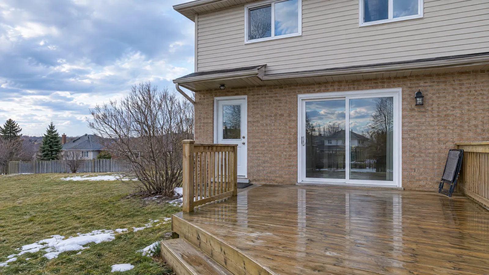 Brick and vinyl-sided house with a sliding patio door and a half-glass garden door onto a deck